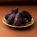 front-view-brown-xurma-sweet-tasty-inside-plate-brown-wooden-desk