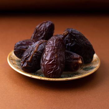 front-view-brown-xurma-sweet-tasty-inside-plate-brown-wooden-desk